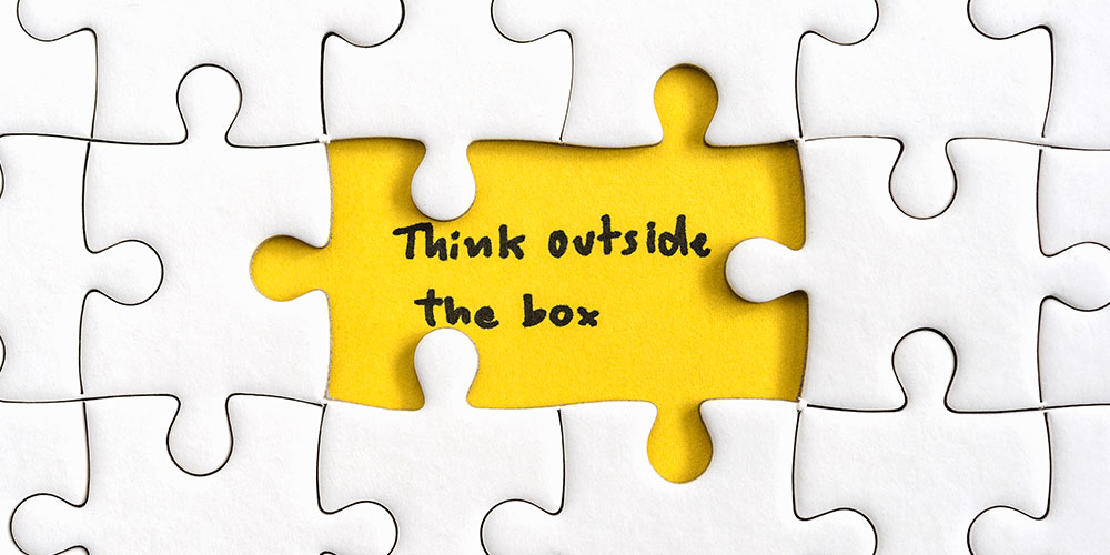 Puzzlebild mit Schrift think outside the box - Kreativität fördern in Unternehmen - Kraus & Partner
